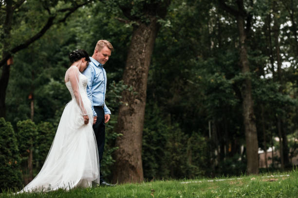 belle mariée et marié étreignant et embrassant le jour de leur mariage à l’extérieur. mariage concept, nouvelle famille - young men young women bride hairstyle photos et images de collection