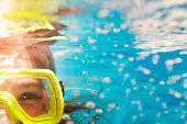 Girl in scuba masks under water, close up portrait