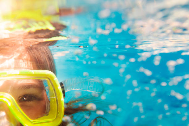 Girl in scuba masks under water, close up portrait Little girl in colorful swimming mask smiling looking at camera under water scuba mask stock pictures, royalty-free photos & images