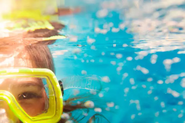 Photo of Girl in scuba masks under water, close up portrait