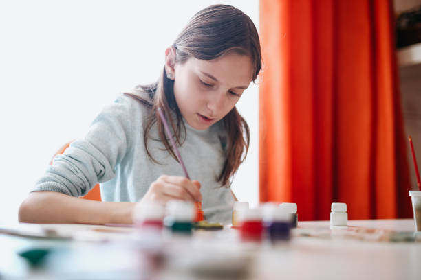 istock Girl decorating clay pottery 1218206080