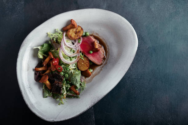 istock beef tagliata with vegetables. Close-up, low key, gray background. Copy space, top view 1218206320