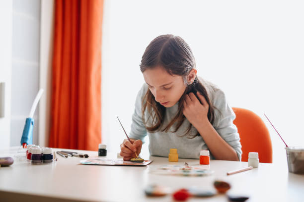 istock Girl decorating clay pottery 1218209342