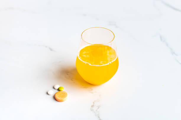 multivitamines avec le verre d’eau - pill vitamin b vitamin pill orange photos et images de collection