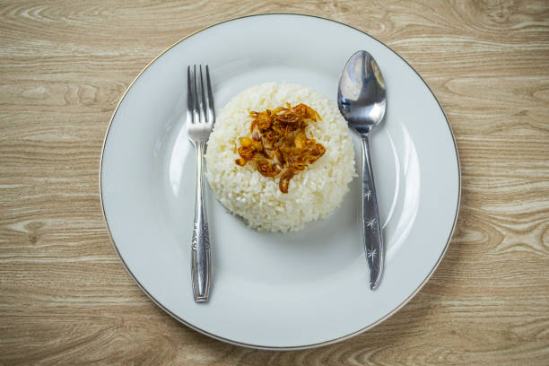 istock Nasi putih or white rice in white plate with fried shallot on the top. 1218210839