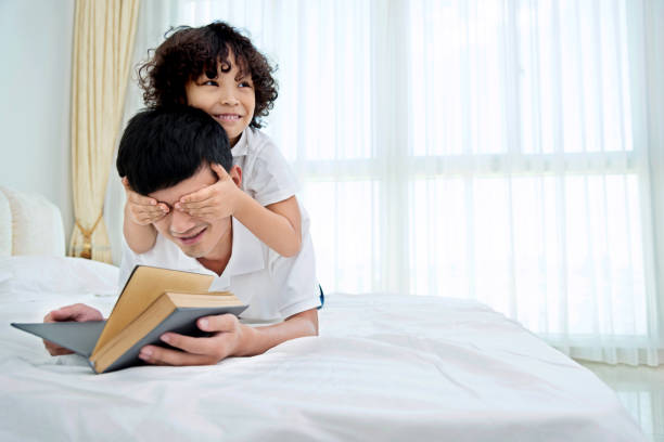 istock Little boy covering his father's eyes 1218210926
