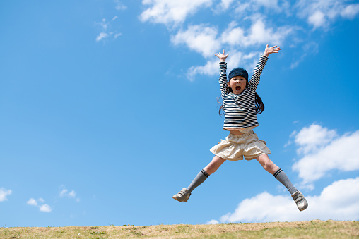 Child jumping with open arms
