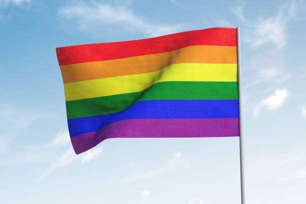 istock LGBT flag waving in the wind. Sky in background. 1218211677