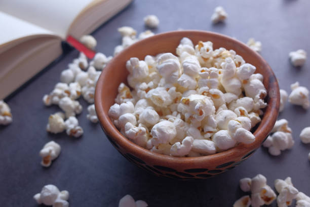 istock close up of popcorn in bowl and book on table 1218214611