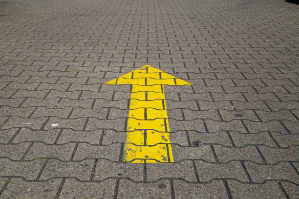 Simple straightforward solution concept: Yellow arrow an paving blocks showing direction straight ahead - Germany