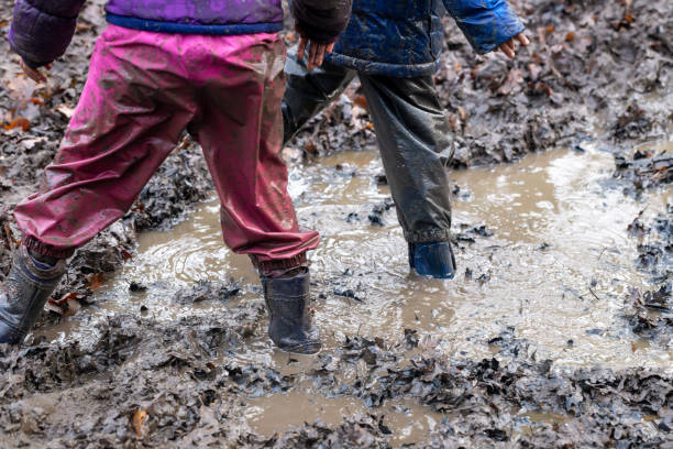 istock Young children playing in a mud puddle 1218215160