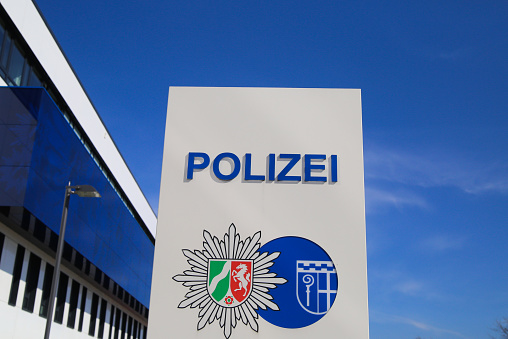 Mönchengladbach, Germany (NRW) - April 10. 2020: Isolated german Polizei logo in front of police station against blue sky