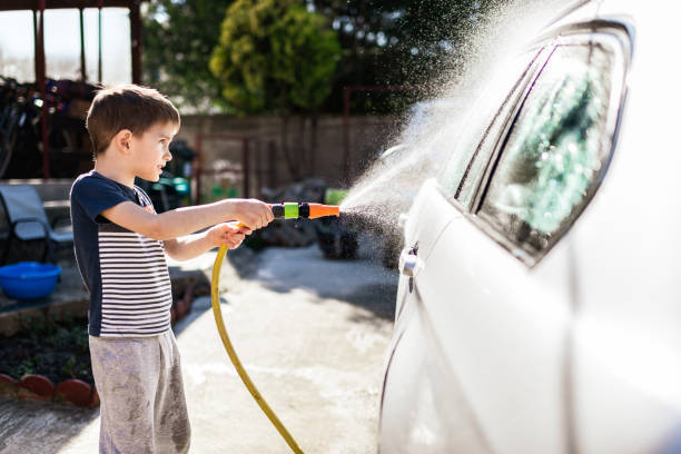 An Asian man is washing car at home