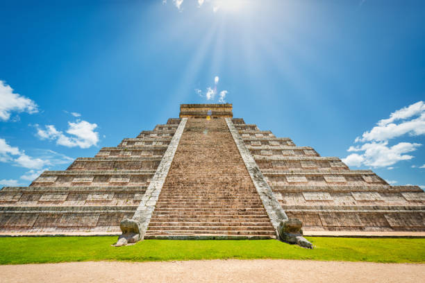 Mexico El Castillo Chichen Itza Maya Temple Pyramid of Kukulcan Against the Sun: Chichen Itza - El Castillo Maya Temple - Pyramid of Kukulcan on a beautiful summer day under blue skyscape. The Temple of Kukulkan usually referred to  El Castillo "the Castle". This step pyramid is about 30m - 98feet high and consists of 9 square terraces, with a 6m high temple up on the pyramid top. Chichen Itza, Yucatan, Mexico, North America. kukulkan pyramid photos stock pictures, royalty-free photos & images