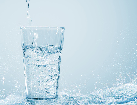 tumbler with refreshing soda in water wave on abstract background