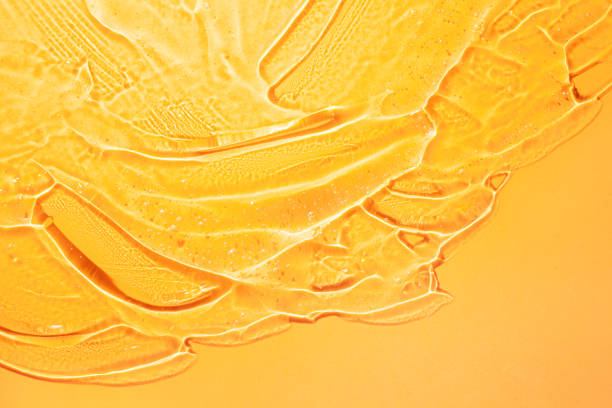 gel cosmético transparente de oro naranja amarillo con burbujas sobre fondo aislado - vitamin c fotografías e imágenes de stock
