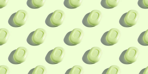 Seamless isometric pattern of mint green soap bars on light green background, with trendy sunlight and hard shadows. Wash your hands. Body hygiene, protection against bacteria and viruses