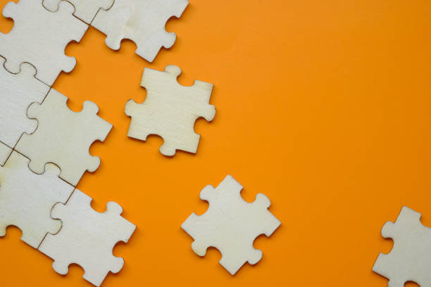 istock Pieces of puzzle on orange background, close up 1218223639