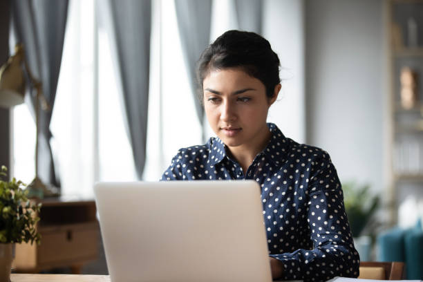 istock Serious Indian woman working on laptop, looking at screen 1218223743