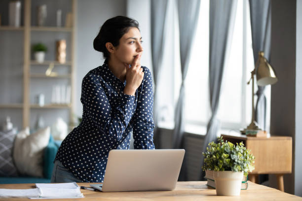 istock Thoughtful Indian woman standing at desk, pondering task 1218223750