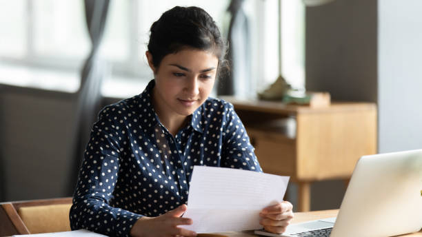 istock Focused Indian woman reading letter with important information 1218223773