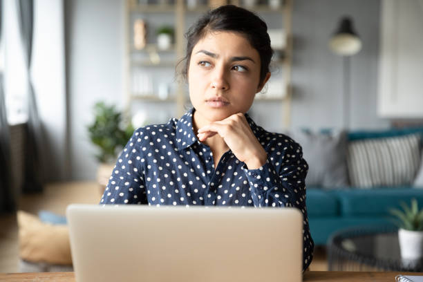 istock Thoughtful young Indian woman pondering task, working on project 1218223778