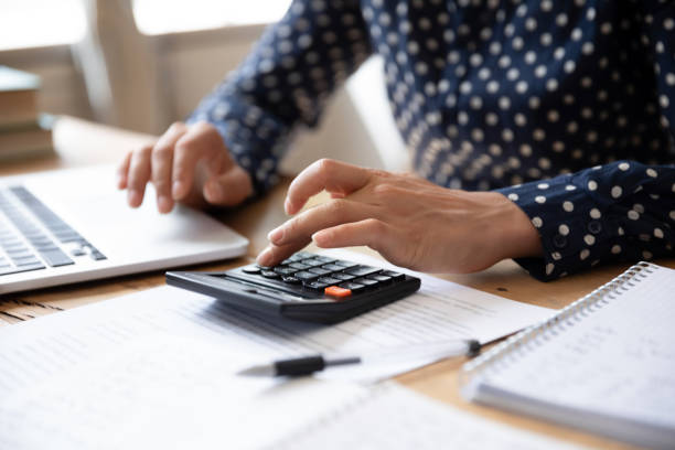 istock Close up Indian woman planning budget, using calculator and laptop 1218223784