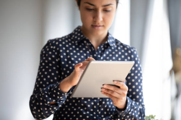 istock Close up focused Indian female typing on computer tablet screen 1218223802