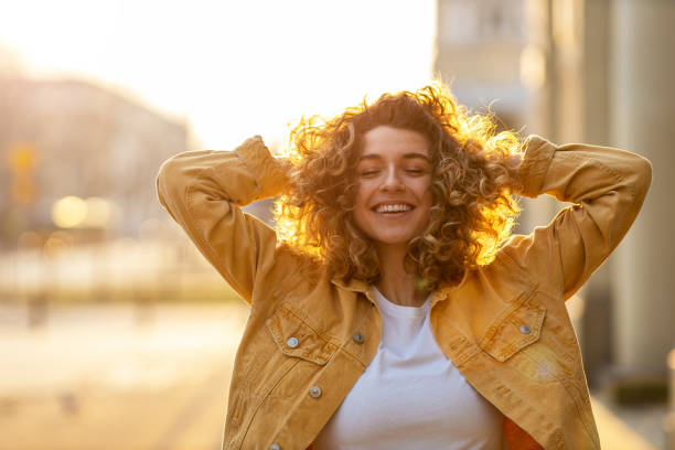 portret młodej kobiety z kręconymi włosami w mieście - blond hair fashion smiling attractive female zdjęcia i obrazy z banku zdjęć