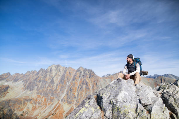 istock Mature man with backpack hiking in mountains in autumn, resting. 1218226107