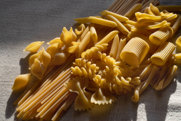 pasta secca italiana crudo - italian cuisine dry pasta directly above foto e immagini stock
