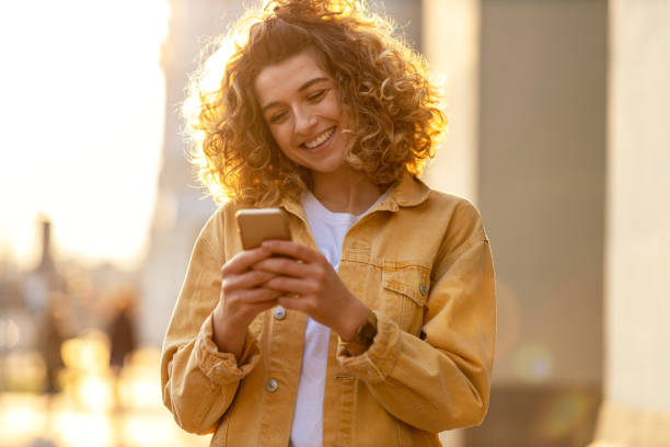 istock Young hipster woman using smartphone at sunset 1218228928
