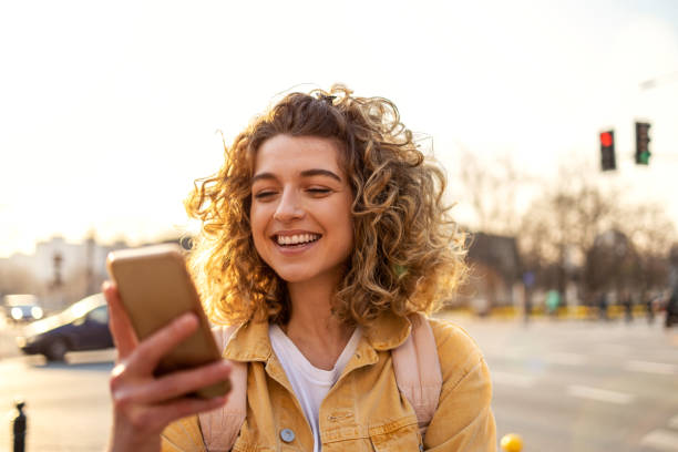 istock Young hipster woman using smartphone at sunset 1218228949