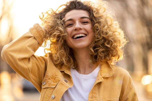 retrato de mujer joven con el pelo rizado en la ciudad - smiling happy fotografías e imágenes de stock