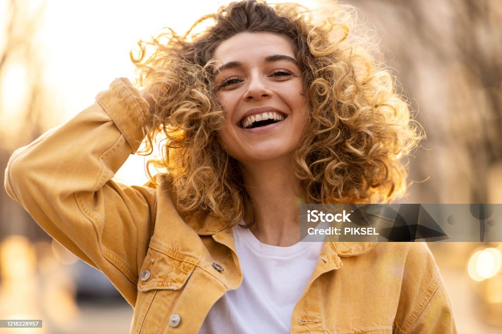 Portrait of young woman with curly hair in the city One Woman Only Stock Photo