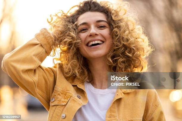Foto de Retrato De Jovem Com Cabelo Encaracolado Na Cidade e mais fotos de stock de Só Uma Mulher - Só Uma Mulher, Felicidade, Sorrindo