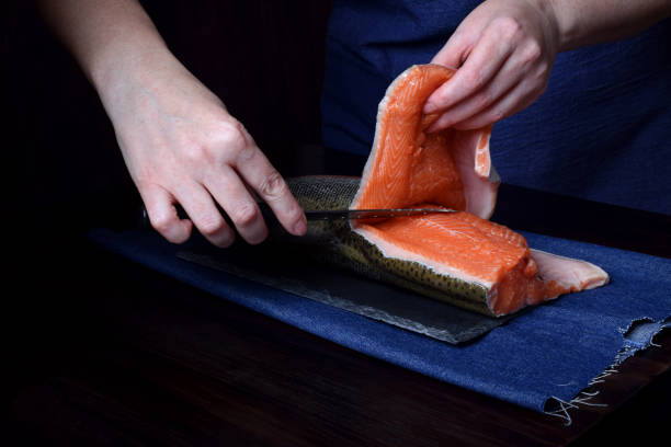 istock Cook is cutting carcass of a red fish with a knife 1218229251