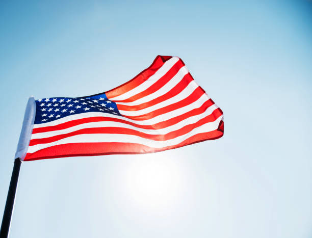 istock American flag waving against blue sky 1218230896