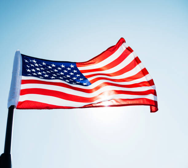 istock American flag waving against blue sky 1218230901