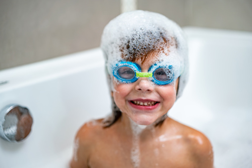 Cute boy with goggles is having fun at bathing