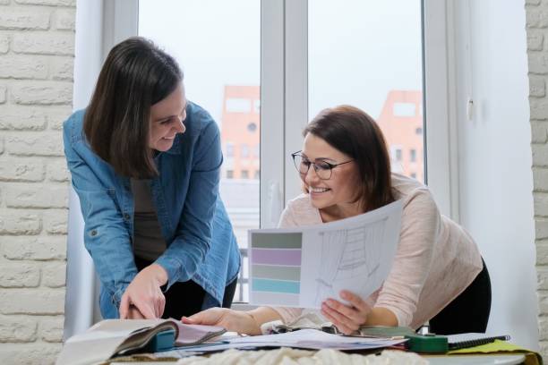 istock Females textile designer, decorator and client watch palettes with fabrics 1218231848