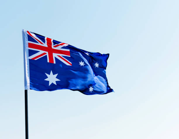 istock Waving Australia flag against blue sky 1218232129