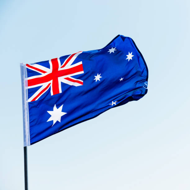 istock Waving Australia flag against blue sky 1218232931