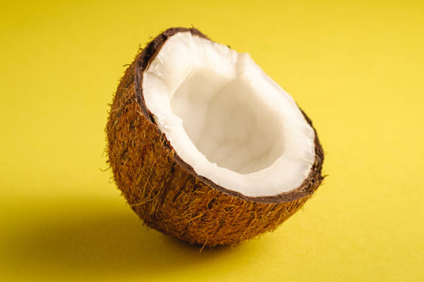 istock Single coconut fruit on yellow plain background, abstract food tropical concept, angle view macro 1218233252