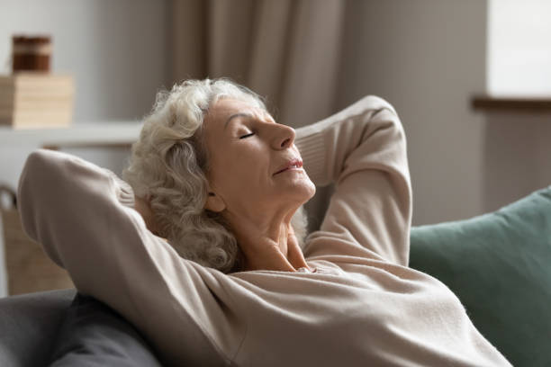 istock Serene middle aged woman daydreaming on couch. 1218234384