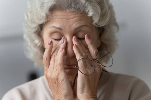 усталая зрелая женщина потирает носовой мост после смыв очков. - portrait senior adult confusion women стоковые фото и изображения