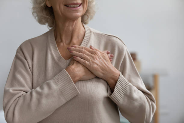 istock Middle aged woman thanking God with folded hands on heart. 1218234425