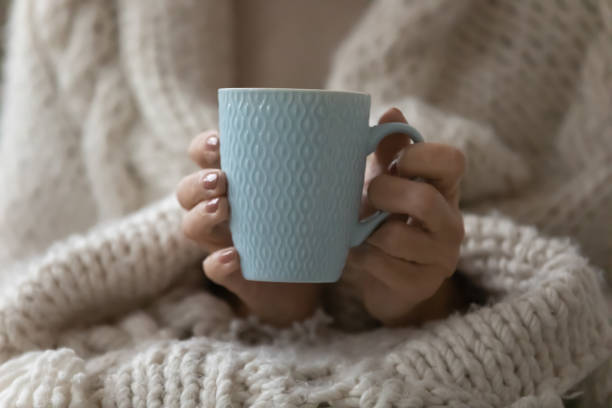 istock Close up focus on mug with beverage in female hands. 1218234437