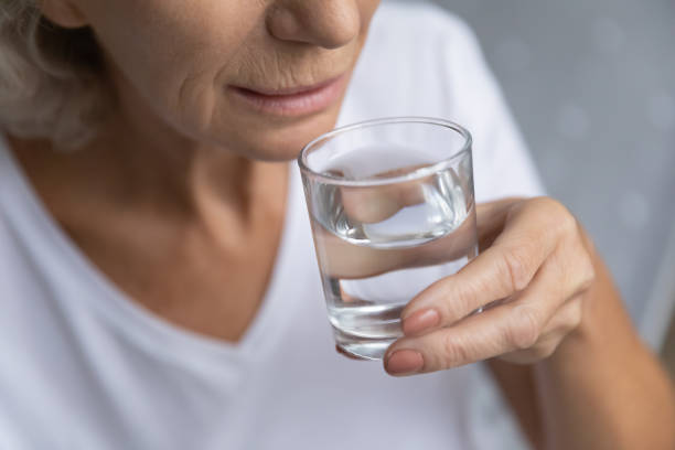 istock Elderly senior granny drinking fresh pure water. 1218234451
