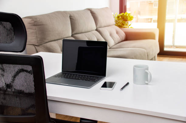 istock laptop and a smart phone on a desk in an empty home office 1218234764